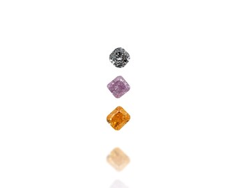 May include: Three colorful gemstones: a gray, a purple, and an orange diamond. Each stone is square-cut and reflects light, creating a sparkling effect. The gems are arranged vertically against a white background.