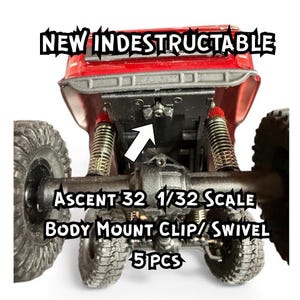 May include: Red and black Ascent 32 1/32 scale model car body mount clip/swivel. The image shows the underside of the model car with the text "NEW INDESTRUCTABLE" and "5 PCS". The car has large tires and suspension.