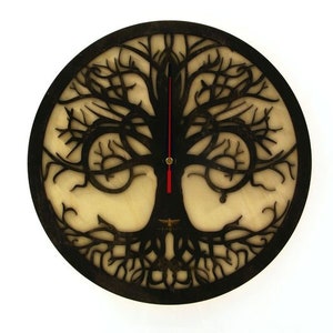 May include: A black wooden clock with a tree of life design. The clock face is white with black hands. The tree is intricately carved and has a dark brown finish.