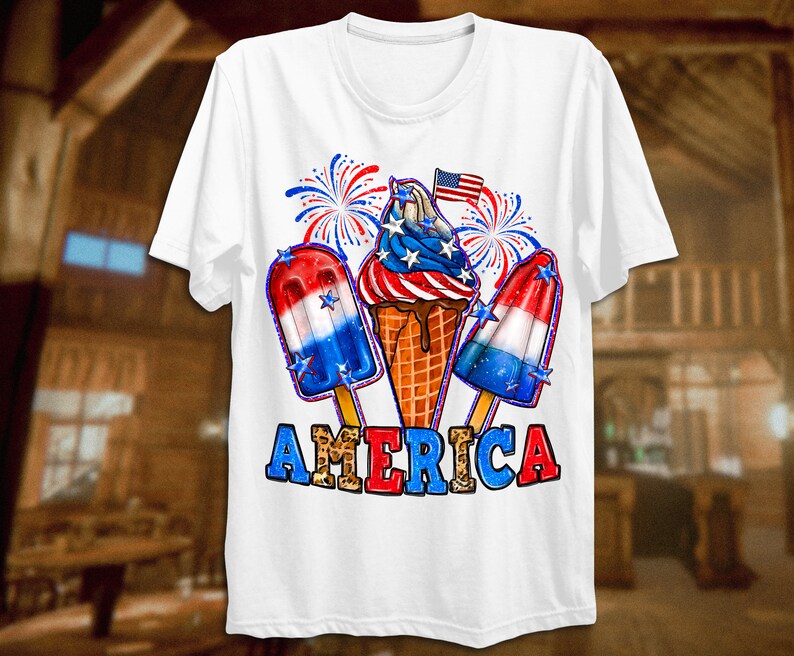 May include: White t-shirt featuring a red, white and blue ice cream cone, popsicles, and fireworks graphic. The text "AMERICA" is printed in red, white and blue with a leopard print pattern.