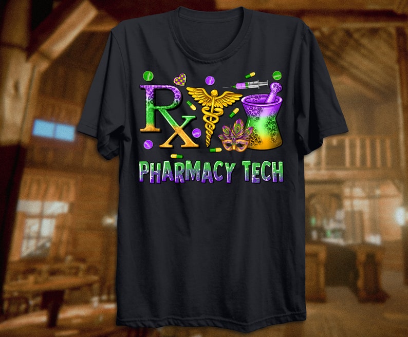 May include: Black t-shirt with a colorful graphic design. The design includes the letters "Rx" in green and orange, a gold caduceus, a mortar and pestle, and the words "PHARMACY TECH" in purple and green. The design also features pills and a syringe.