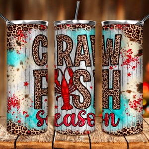May include: A stainless steel tumbler with a leopard print design and the words "Crawfish Season" in red and white lettering. The tumbler has a blue and white background with red splatters.