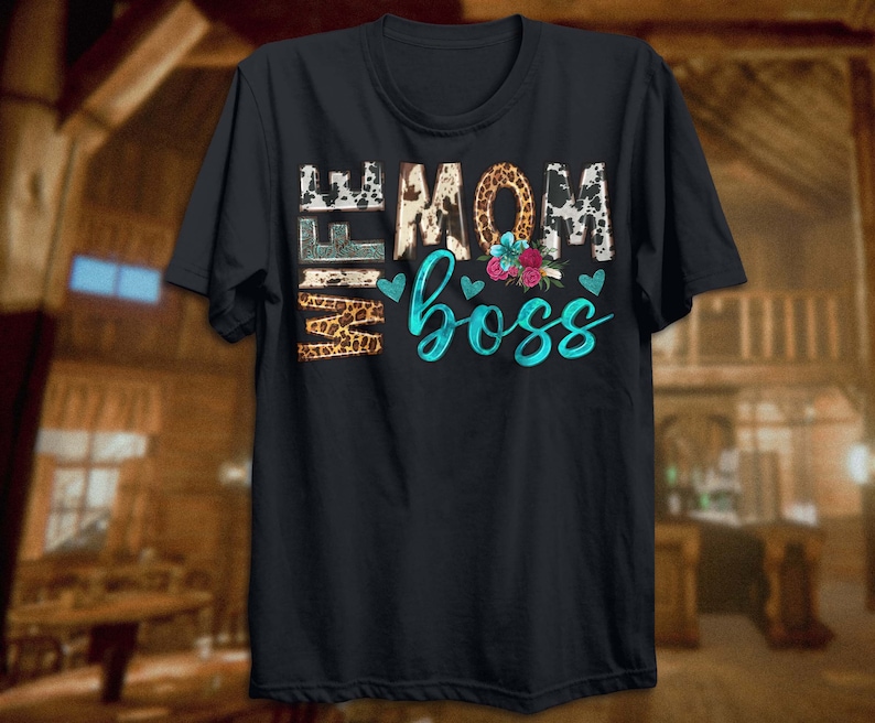 May include: Black t-shirt with a graphic print of "Wife Mom Boss" in turquoise and white lettering with animal print accents and floral details.