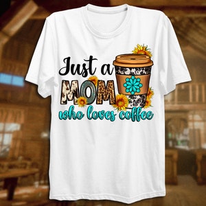 May include: White t-shirt featuring the text "Just a MOM who loves coffee." The word "MOM" has a cow print design. A coffee cup with a floral design and sunflowers is on the right side of the shirt.