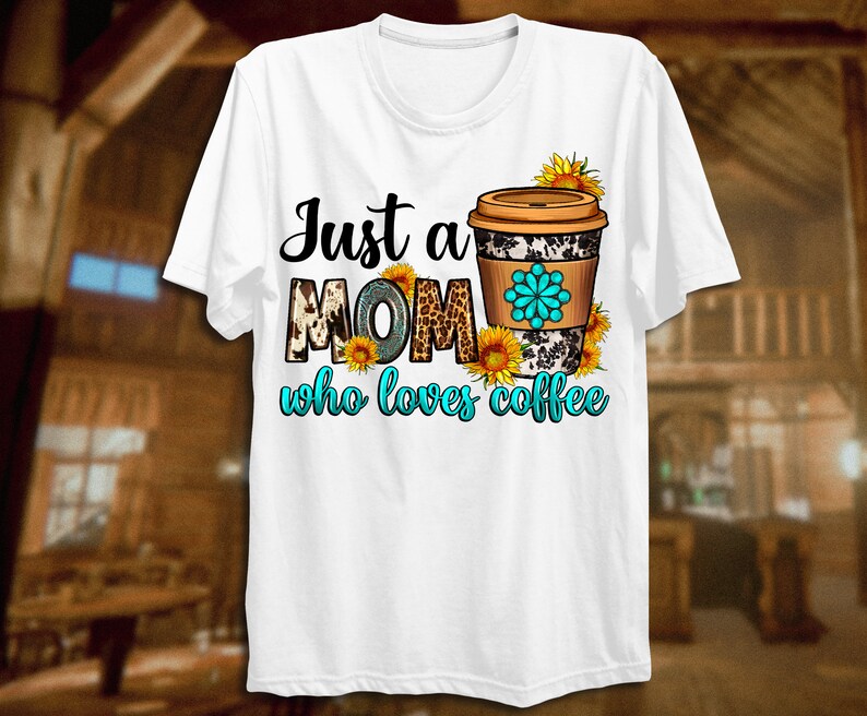 May include: White t-shirt featuring the text "Just a MOM who loves coffee." The word "MOM" has a cow print design. A coffee cup with a floral design and sunflowers is on the right side of the shirt.