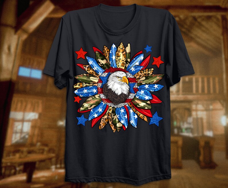 K&ouml;nnte beinhalten: Ein schwarzes T-Shirt mit einem Aufdruck eines Wei&szlig;kopfseeadlers in einem rot-wei&szlig;-blauen Sternendesign. Der Adler ist von Tarnung, Leopardenmuster und Federn umgeben.