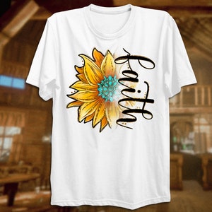 K&ouml;nnte beinhalten: Wei&szlig;es T-Shirt mit einer gelben Sonnenblume und dem Wort "Glaube" in schwarzer Schrift.
