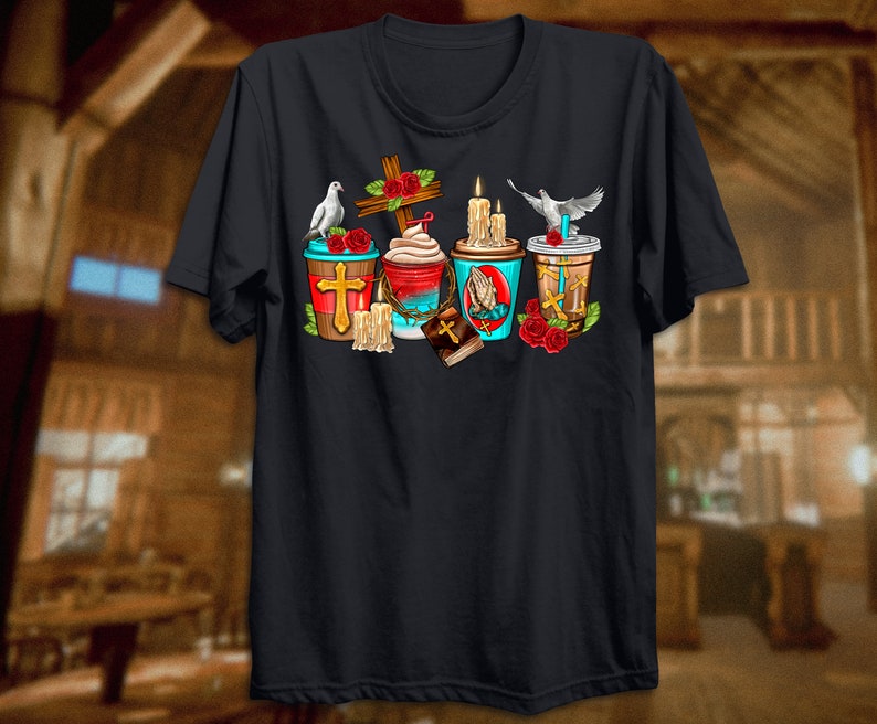 Puede incluir: Una camiseta negra con un dise&ntilde;o gr&aacute;fico de cuatro tazas de caf&eacute; con im&aacute;genes religiosas. Cada taza tiene una cruz, una paloma, una vela y una biblia. Las tazas est&aacute;n rodeadas de rosas rojas.