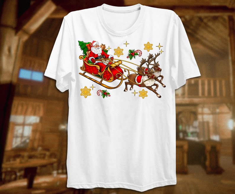 Puede incluir: Camiseta blanca con un dise&ntilde;o navide&ntilde;o que presenta a Pap&aacute; Noel en un trineo rojo tirado por dos renos. El dise&ntilde;o incluye estrellas doradas, bastones de caramelo y acebo.
