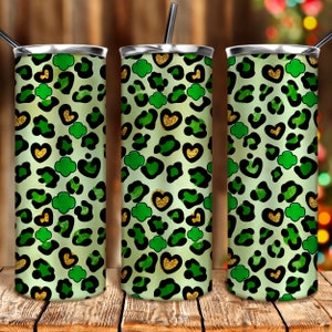 May include: Three stainless steel tumblers with a green and gold leopard print design. The tumblers have a white background with green shamrocks and gold hearts.