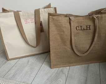 May include: Two tote bags, one white canvas with pink embroidered initials "E.D." and one brown burlap with brown embroidered initials "C.L.H."