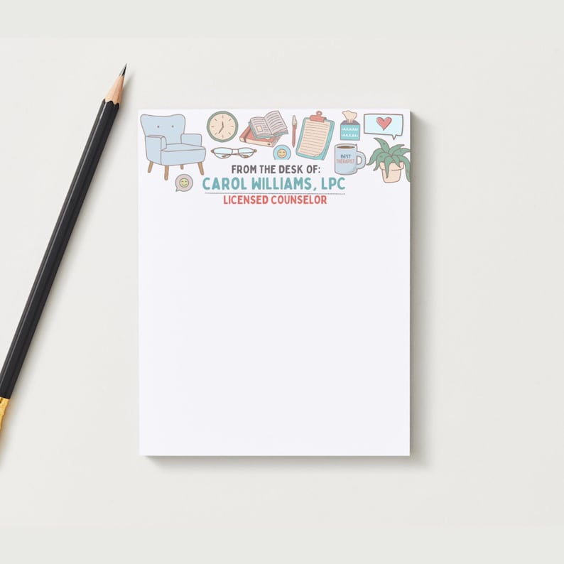 May include: A white notepad with a decorative border featuring a light blue armchair, clock, glasses, open book, clipboard, coffee mug, and plant. The notepad includes the text "FROM THE DESK OF: CAROL WILLIAMS, LPC LICENSED COUNSELOR."