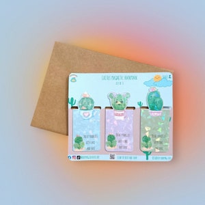 May include: A set of three cactus magnetic bookmarks. Each bookmark features a different cactus design with a smiling face, set against a pastel background. The text "Treat Yourself With Care and Love" is printed on each bookmark. The set comes with a brown envelope.