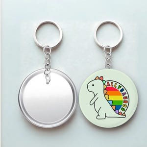 May include: Two keychains. One is a blank silver circle. The other is a light green circle with a cartoon dinosaur with a rainbow spine and the text "ALLYSAURUS" in a circle around it. Both have silver key rings.