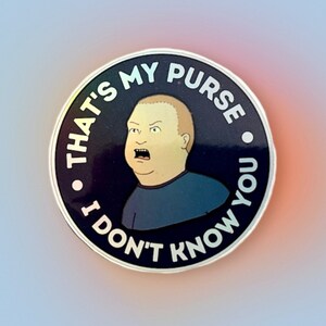 May include: A round sticker with a black background and white text. The text reads "That's my purse. I don't know you." and features a cartoon image of a man with a surprised expression.