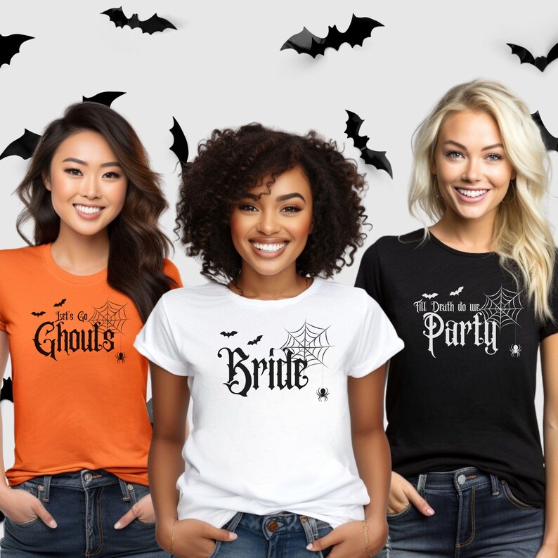 May include: Three women wearing Halloween-themed t-shirts. The shirts are orange, white, and black, each with a different spooky phrase in gothic font: "Let's Go Ghouls", "Bride", and "Till Death do us Party". Black bat cutouts decorate the background.