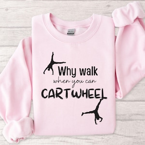 May include: Pink sweatshirt with the text "Why walk when you can cartwheel" and a silhouette of a person doing a cartwheel.
