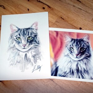May include: A watercolor painting of a gray and white cat with green eyes. The cat is looking directly at the viewer. The painting is signed "Lilly".