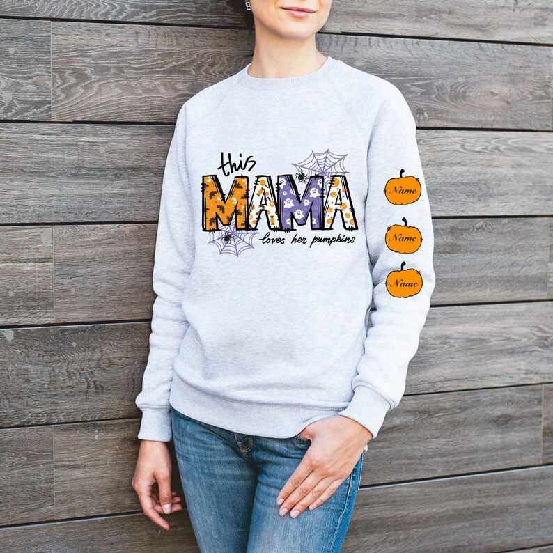 Pode incluir: Camisola cinzenta com o texto "This Mama loves her pumpkins" e tr&ecirc;s ab&oacute;boras laranja com a palavra "Name" em cada uma.