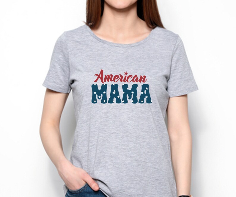 May include: A light gray t-shirt with the text "American MAMA" in red and blue. The word "American" is in a script font, and "MAMA" is in a block font with white stars.