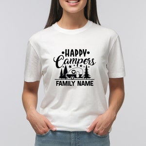 Puede incluir: Camiseta blanca con texto negro que dice "Happy Campers" con un gr&aacute;fico de autocaravana y estrellas. El texto "FAMILY NAME" est&aacute; debajo del gr&aacute;fico.