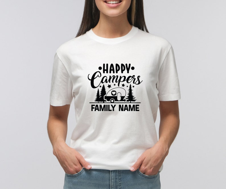 Puede incluir: Camiseta blanca con texto negro que dice "Happy Campers" con un gr&aacute;fico de autocaravana y estrellas. El texto "FAMILY NAME" est&aacute; debajo del gr&aacute;fico.