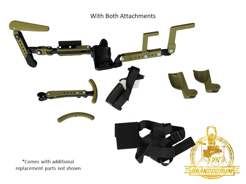 May include: A green and black drum throne attachment with a strap and multiple adjustable parts. The text "With Both Attachments" is visible at the top of the image. The text "*Comes with additional replacement parts not shown" is visible at the bottom of the image.