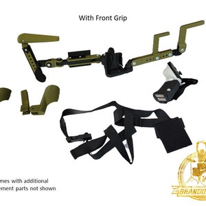 May include: A green and black drum set accessory with a front grip, two arm straps, and a shoulder strap. The accessory is designed to be worn on the body and allows for hands-free drumming. The text "With Front Grip" is visible in the image. The text "*Comes with additional replacement parts not shown" is also visible in the image.