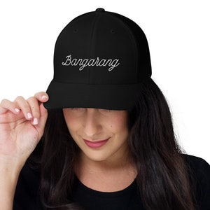 May include: A black mesh trucker hat with a white embroidered cursive script that says "Bangarang".