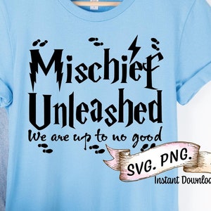 May include: A light blue t-shirt with a black graphic that says "Mischief Unleashed" with a lightning bolt and footprints. The text below the graphic says "We are up to no good". The shirt is on a hanger with a pair of jeans and a hat.