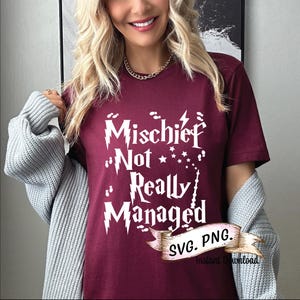 May include: A maroon t-shirt with the text "Mischief Not Really Managed" in a white, stylized font. The design includes stars and a wand. The shirt also has a small banner that says "SVG. PNG. Instant Download."