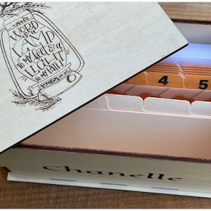 May include: A wooden box with a hinged lid, engraved with the words "Your word is a lamp to my feet & a light to my path - Psalm 119:105". The box is open, revealing a set of index cards with numbers 4 and 5 visible. The box is personalized with the name "Chanelle".