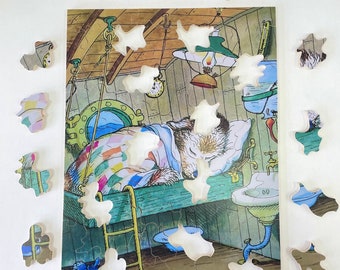 May include: A colorful jigsaw puzzle with a picture of a dog sleeping in a bed. The puzzle pieces are scattered around the image, with some pieces missing. The dog is white with brown spots and is wearing a blue and white blanket. The bed is made of wood and has a white sheet. The background is a light blue.