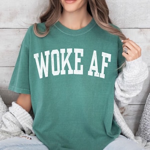 May include: A green t-shirt with the text "WOKE AF" in white lettering.