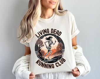 May include: A white t-shirt with a graphic of a skeleton running in a forest with the text "Living Dead Running Club".