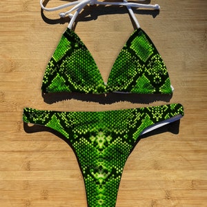 May include: Green snake print bikini top and bottom with white trim.