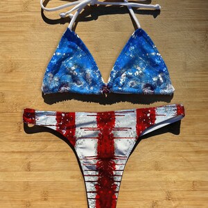 May include: A blue and white patterned bikini top with white straps and a red and white striped bikini bottom.
