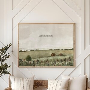 May include: A framed landscape watercolour painting with the text "YOUR TEXT HERE" hangs above a wooden bench with pillows. A potted plant and a round rug complete the scene. The painting depicts a rural scene with fields and buildings.