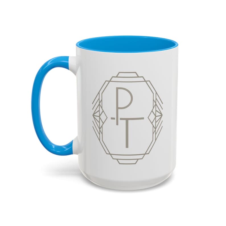 May include: White ceramic mug with a blue interior and handle. The mug features a gray geometric design with the letters "PT" in the center. A simple and stylish design for everyday use.