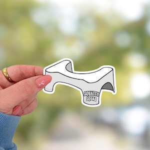 May include: White toilet seat riser sticker with the text "Squatty Squad" printed on it.