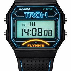 May include: A black digital watch with a perforated strap featuring blue stitching. The watch face displays the text CASIO, F-91W, TRON, and FLYNN'S in blue and orange. The digital screen shows the time 14:08:08 and the day TU with a light blue background.