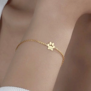 May include: A gold chain bracelet with a paw print charm that says "Jack" on it.