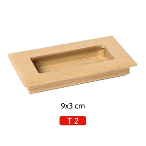May include: A rectangular wooden cabinet pull with a recessed handle. The pull is 9 inches by 3 inches and is labeled "T2".