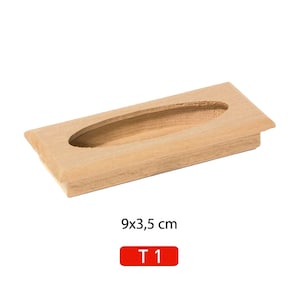 May include: A light wood cabinet pull with an oval cutout. The pull measures 9 by 3.5 inches. The text "T 1" is printed in red below the pull.