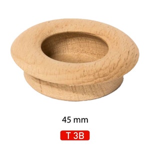 Peut inclure: Un bouton en bois de 45 mm de diamètre avec un trou rond au centre. Le bouton est brun clair et a une finition lisse. Le texte "T 3B" est imprimé en rouge sur fond blanc sous le bouton.