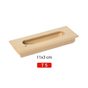 May include: A light wood cabinet pull with a rectangular cutout. The pull measures 11 x 3 cm and is labeled "T 5".