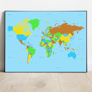 以下が含まれることがあります： さまざまな色の国が描かれた、額入りの世界地図。背景は水色です。地図は黒いフレームに入っており、木製の床の上にある白い壁に表示されています。