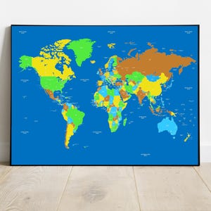 May include: A colorful world map print with a blue background and a black frame. Countries are distinguished by different colors, including green, yellow, brown, and blue. The map is displayed on a white wall above a wooden floor.
