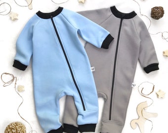 May include: Two baby onesies, one light blue and one gray, with black trim and a zipper down the front.