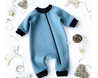May include: A blue baby onesie with black trim and a zipper down the front.